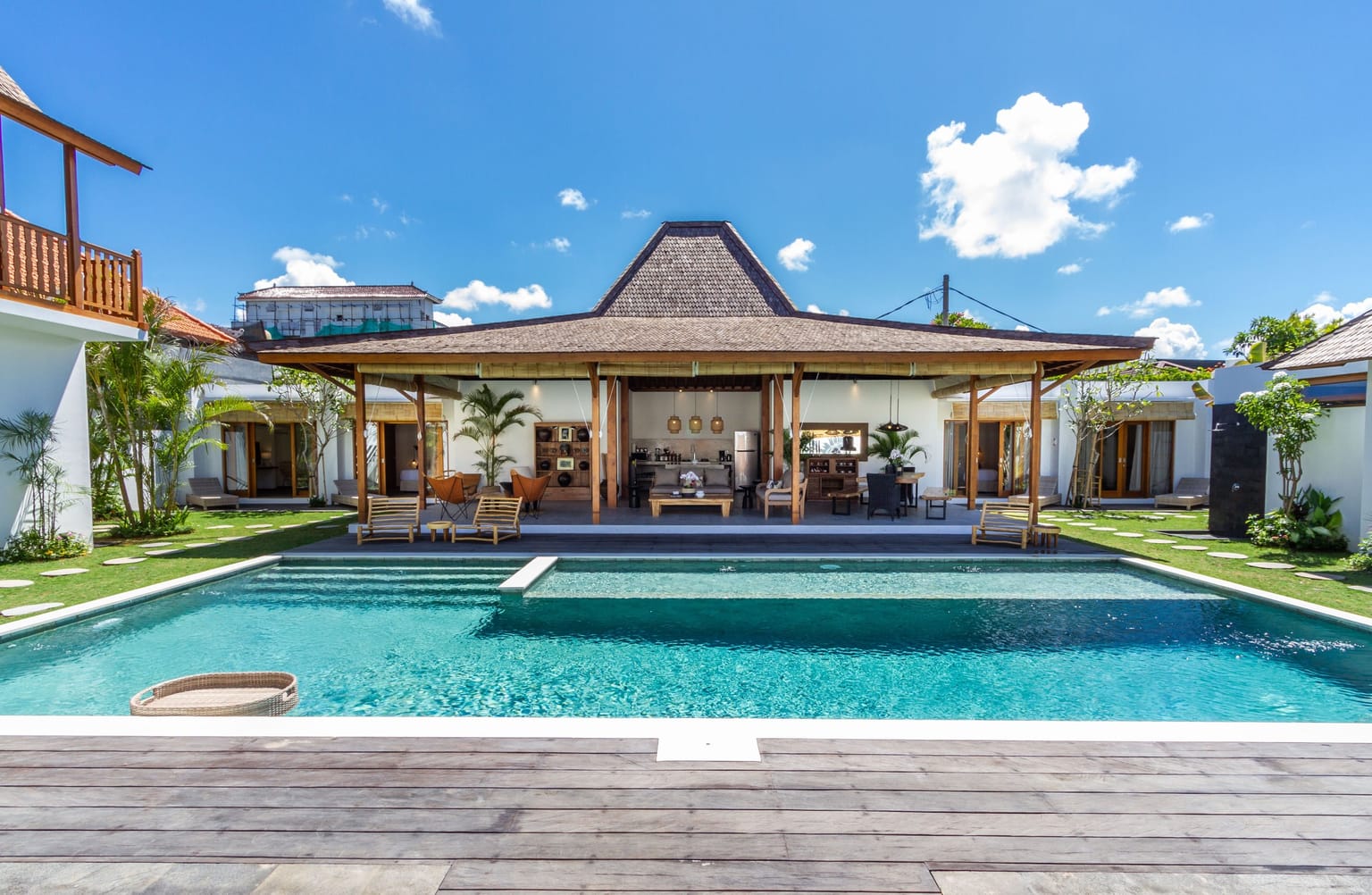 A Balinese villa courtyard with a pool and an open timber pavilion.